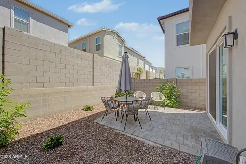 a view of a patio with a table and chairs and potted plants
