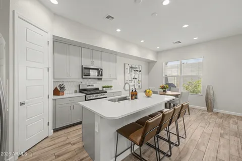 a kitchen with a sink a stove a refrigerator cabinets and wooden floor