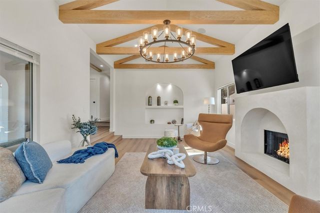 a dining room with chandelier and wooden floor