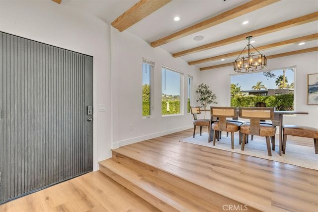 a dining room with chandelier a glass table and chairs