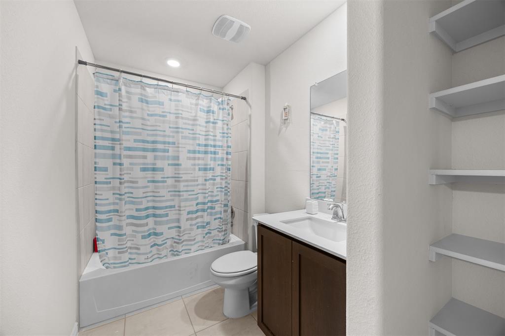 3808 High Country Road Aubrey, TX 76227 - Photo 24 of 36 Bathroom featuring a tub and shower combination with white tile surround, a single vanity with a dark wood-finish cabinet, a white countertop, and tiled flooring