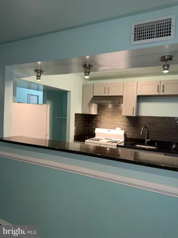 a kitchen with kitchen island a sink stainless steel appliances and cabinets