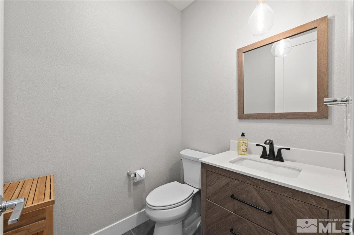 8773 Larkhaven Trail Reno, NV 89523 - Photo 25 of 38 a bathroom with a toilet a sink a mirror and vanity