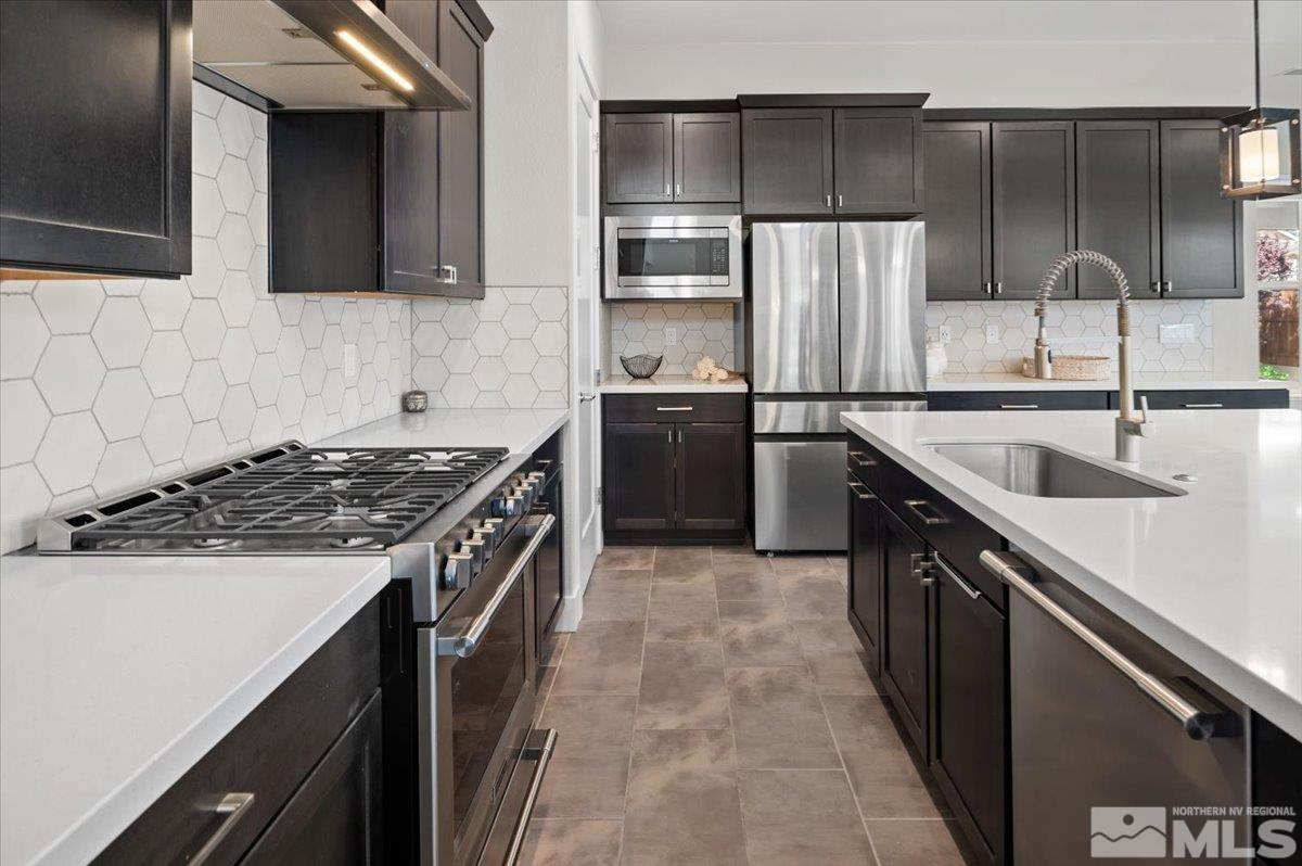 8773 Larkhaven Trail Reno, NV 89523 - Photo 10 of 38 a kitchen with stainless steel appliances granite countertop a sink stove and refrigerator