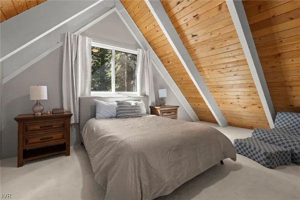 a bedroom with a bed wooden floor and window