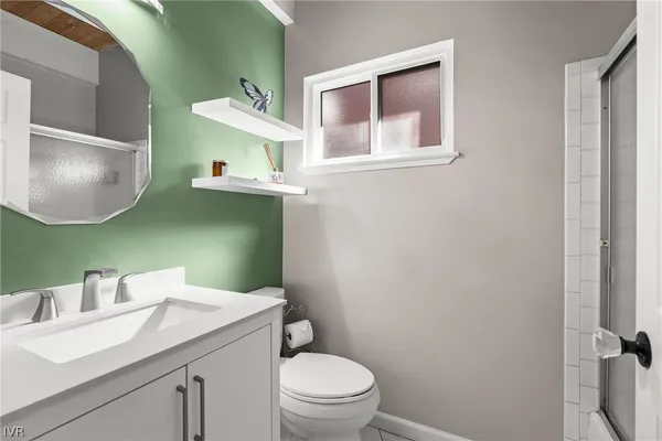 a bathroom with a toilet sink vanity and mirror
