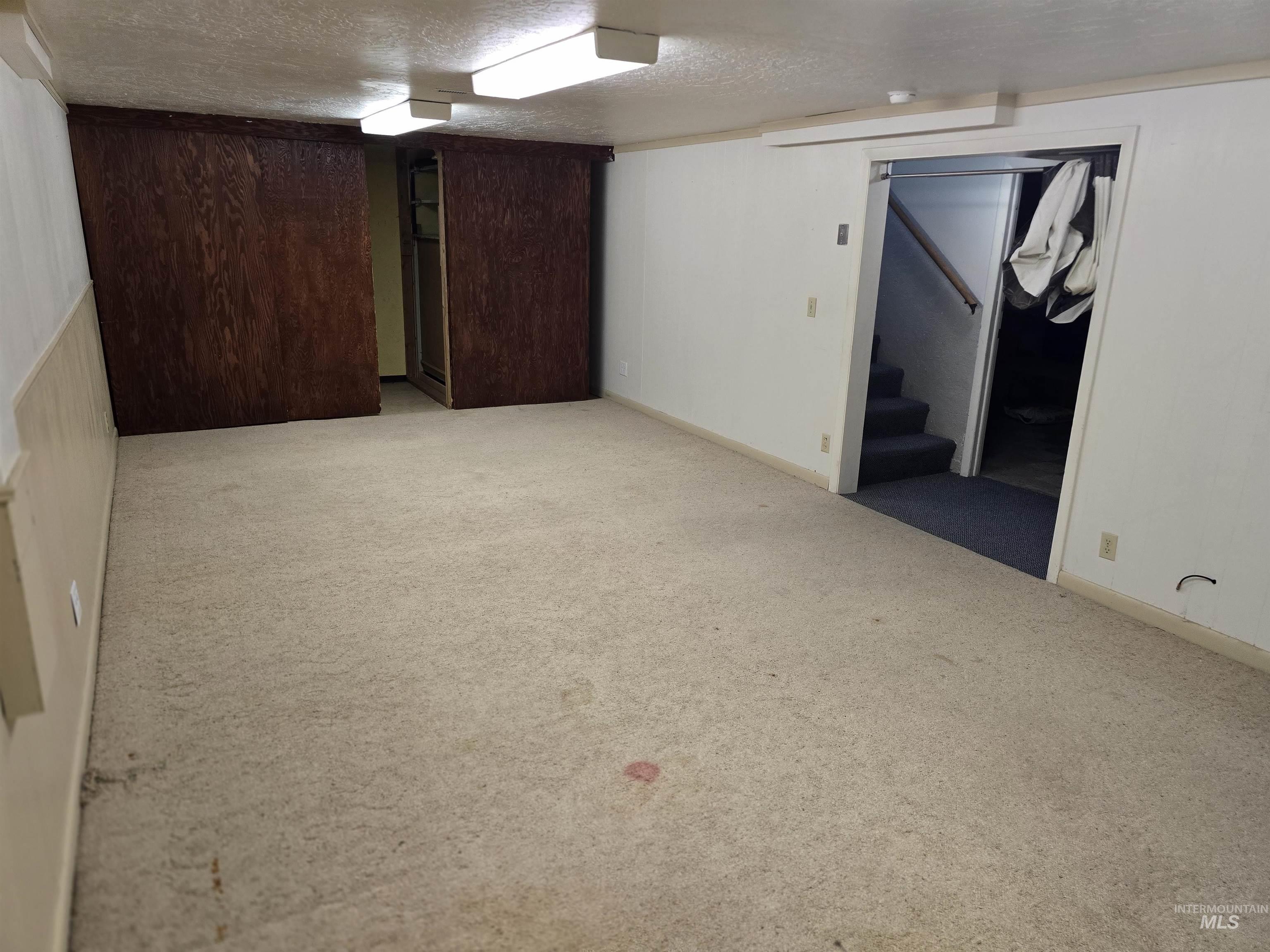 1818 Granada Drive Twin Falls, ID 83301 - Photo 14 of 16 Finished basement with light carpet, stairs, and a textured ceiling