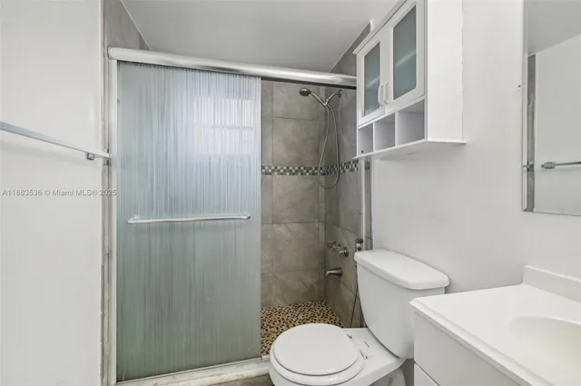 a white toilet sitting next to a bathroom sink