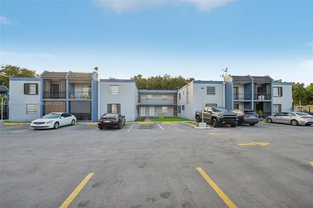 a view of building with cars parked in front of it