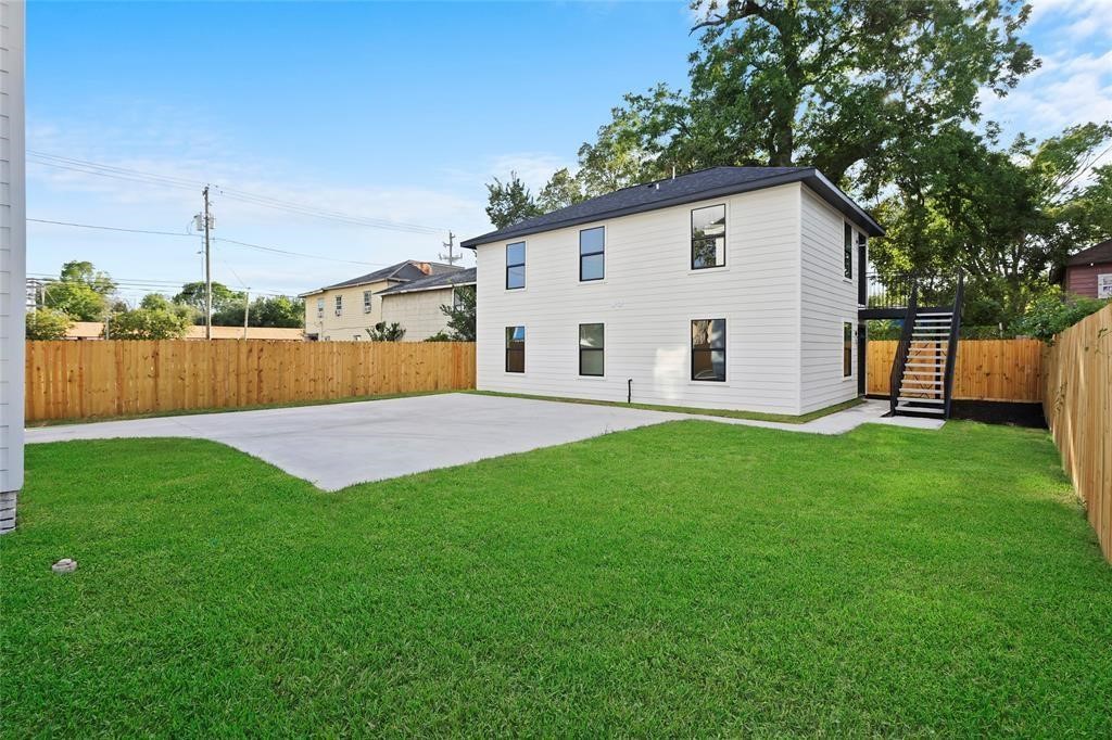 310 Delmar Street, Unit D Houston, TX 77011 - Photo 3 of 13 a view of a backyard with table and chairs and wooden fence