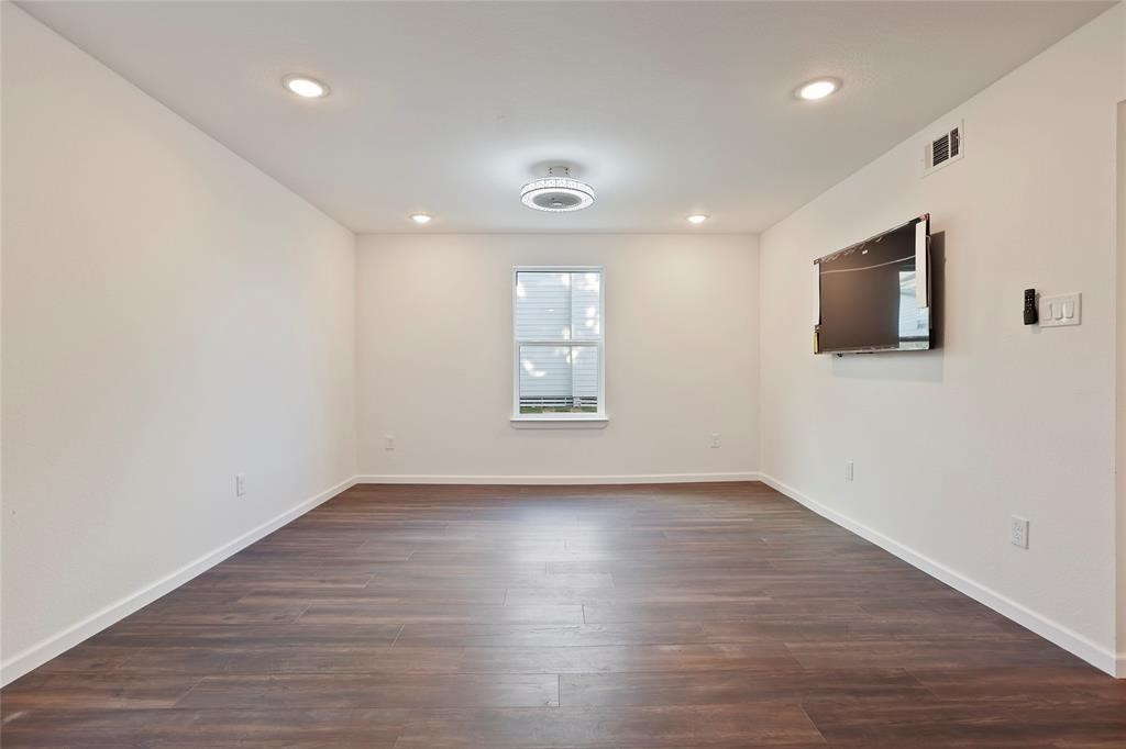 310 Delmar Street, Unit D Houston, TX 77011 - Photo 4 of 13 a view of an empty room with wooden floor and a window
