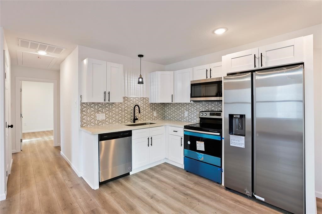 310 Delmar Street, Unit D Houston, TX 77011 - Photo 6 of 13 a kitchen with stainless steel appliances granite countertop a refrigerator and a stove top oven