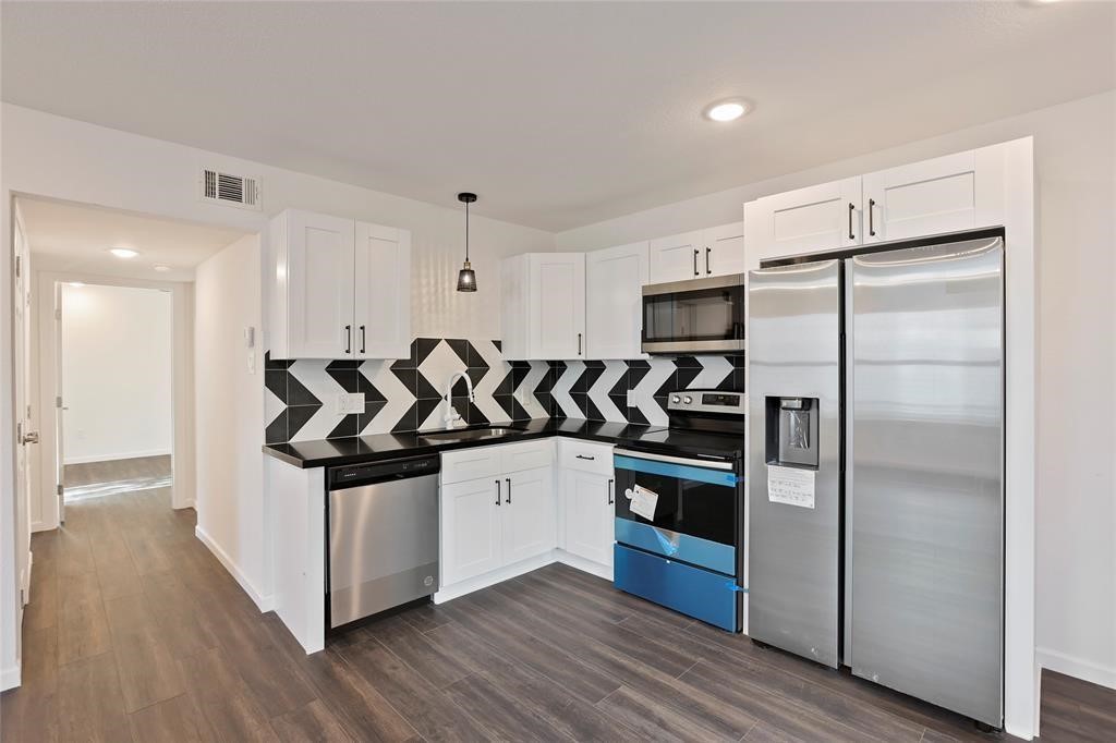 310 Delmar Street, Unit D Houston, TX 77011 - Photo 10 of 13 a kitchen with stainless steel appliances granite countertop a refrigerator and a stove top oven