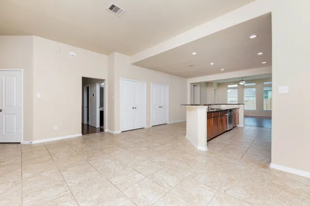 a view of kitchen with stainless steel appliances granite countertop refrigerator and stove top oven
