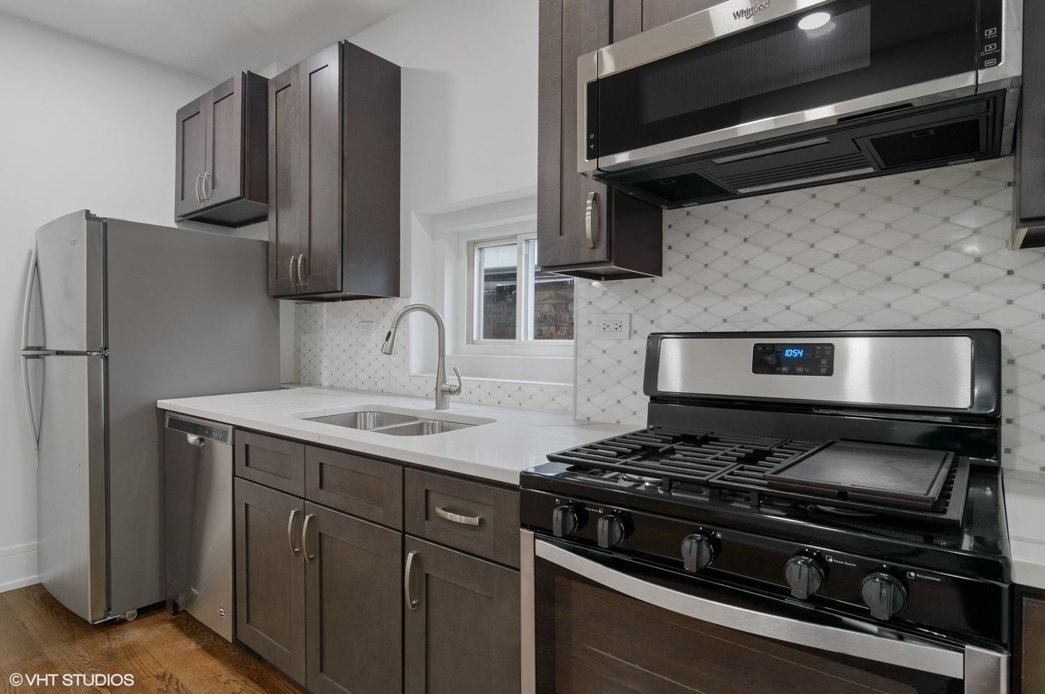1719 West 18th Street, Unit 2R Chicago, IL 60608 - Photo 3 of 8 a kitchen with stainless steel appliances granite countertop a sink stove and refrigerator