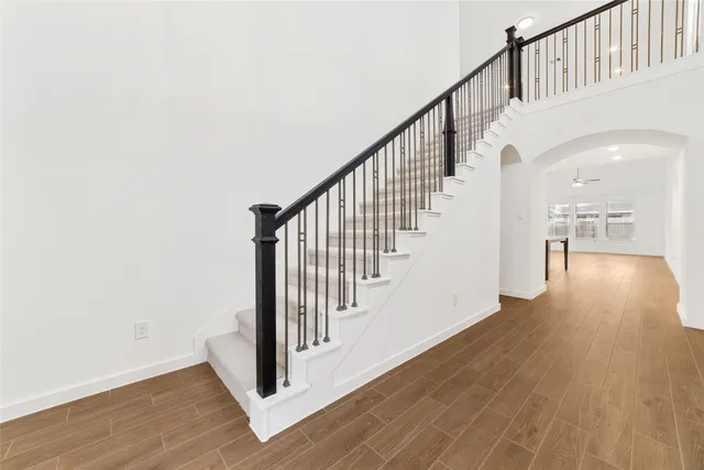 a view of staircase with railing and white walls
