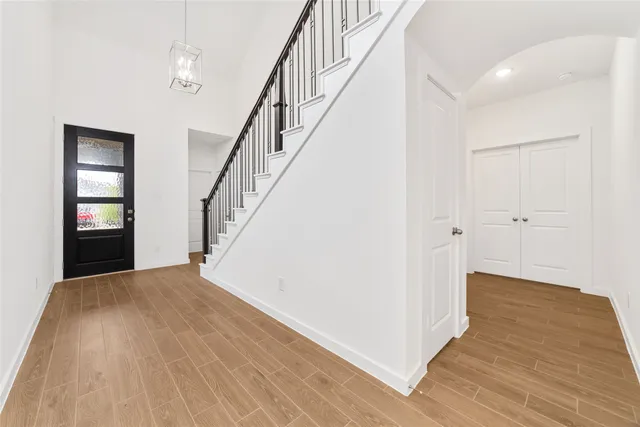a view of a hallway with wooden floor and staircase
