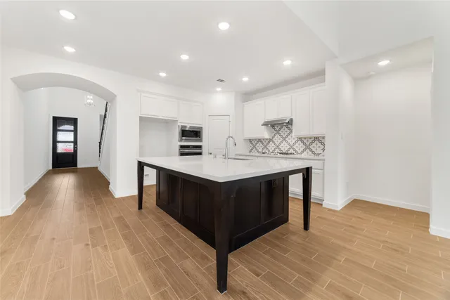 a kitchen with kitchen island a sink stainless steel appliances and cabinets