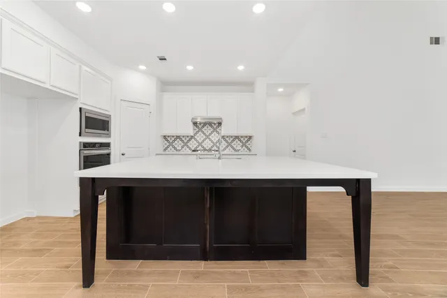 a kitchen with a sink cabinets and wooden floor