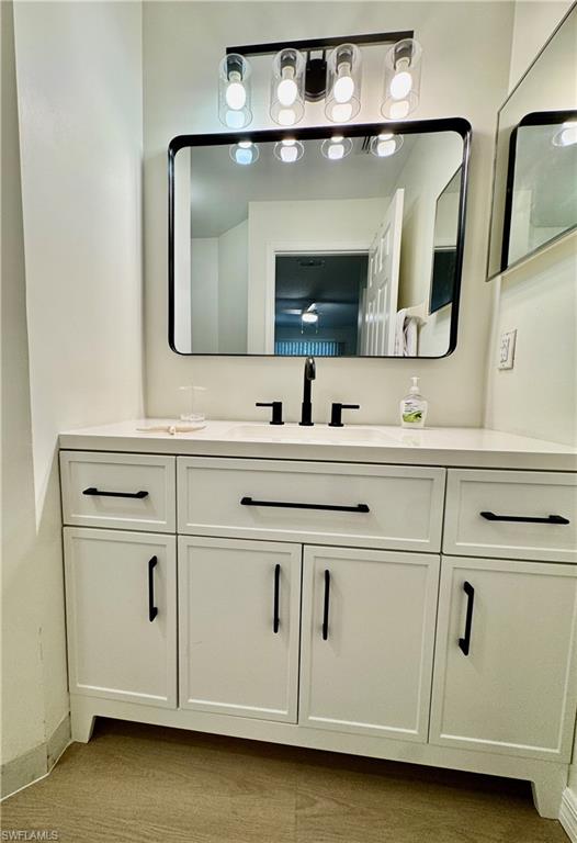 645 Squire Court, Unit 202 Naples, FL 34104 - Photo 29 of 41 a bathroom with a sink vanity and mirror