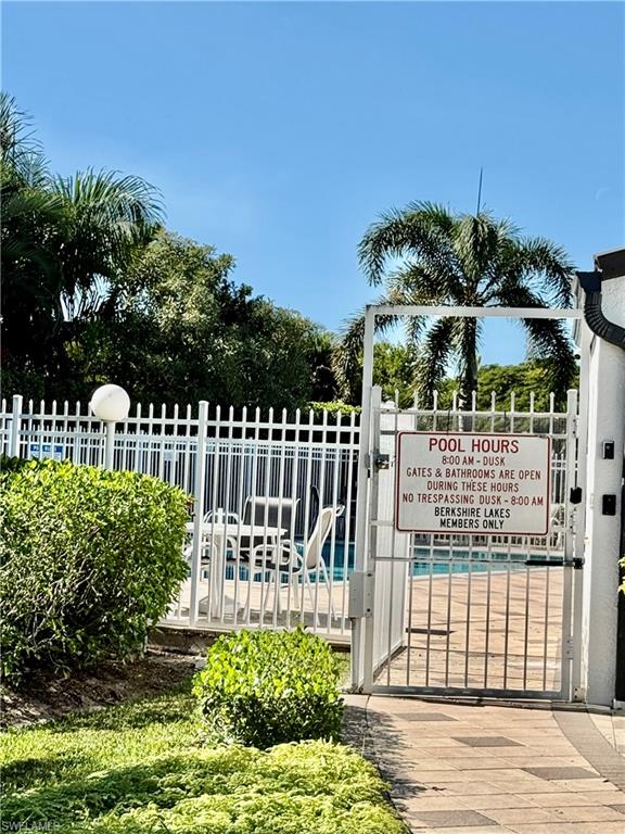 645 Squire Court, Unit 202 Naples, FL 34104 - Photo 36 of 41 a view of a house with a small yard and wooden fence
