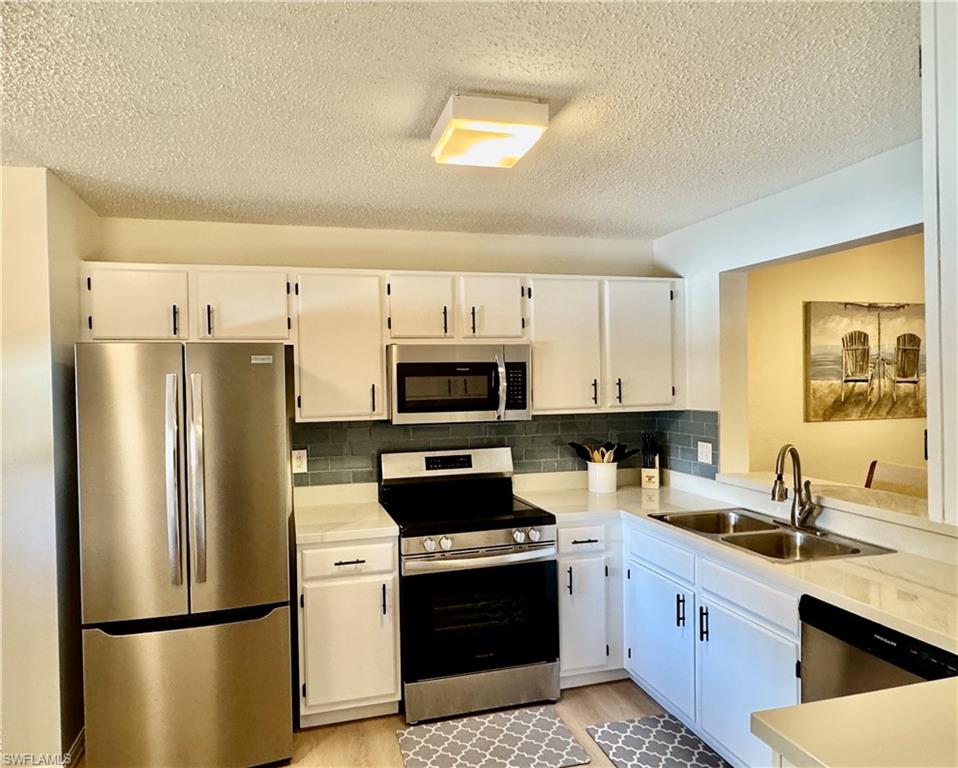 645 Squire Court, Unit 202 Naples, FL 34104 - Photo 4 of 41 a kitchen with stainless steel appliances a refrigerator stove microwave and sink