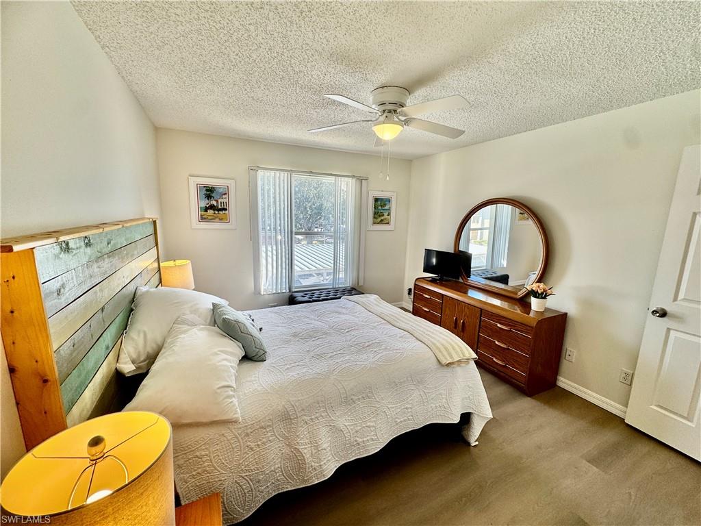 645 Squire Court, Unit 202 Naples, FL 34104 - Photo 8 of 41 a bedroom with a bed and dresser