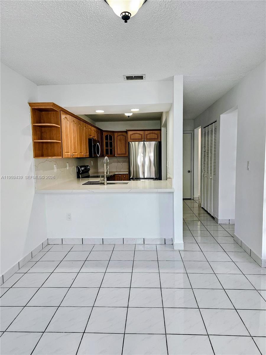 15581 Southwest 144th Court Miami, FL 33177 - Photo 11 of 37 a living room with a washing machine and a sink