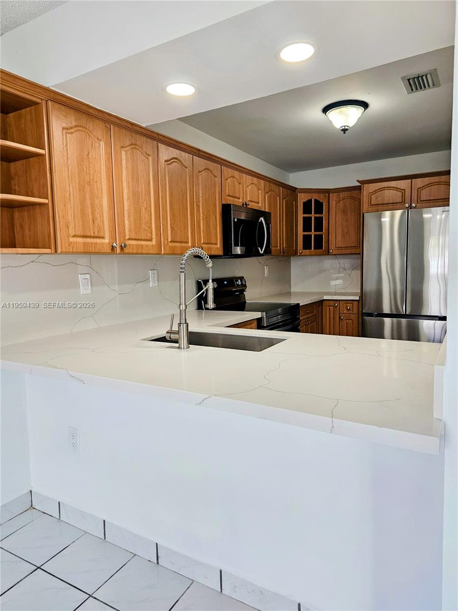 15581 Southwest 144th Court Miami, FL 33177 - Photo 24 of 37 a kitchen with stainless steel appliances a refrigerator sink and microwave