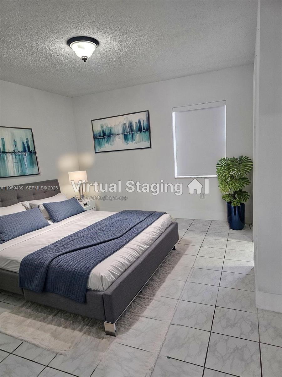 15581 Southwest 144th Court Miami, FL 33177 - Photo 26 of 37 a bedroom with a bed and a potted plant