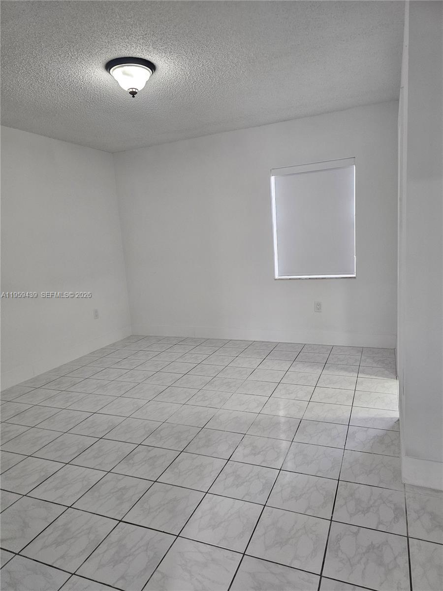 15581 Southwest 144th Court Miami, FL 33177 - Photo 27 of 37 an empty room with white walls and tiles