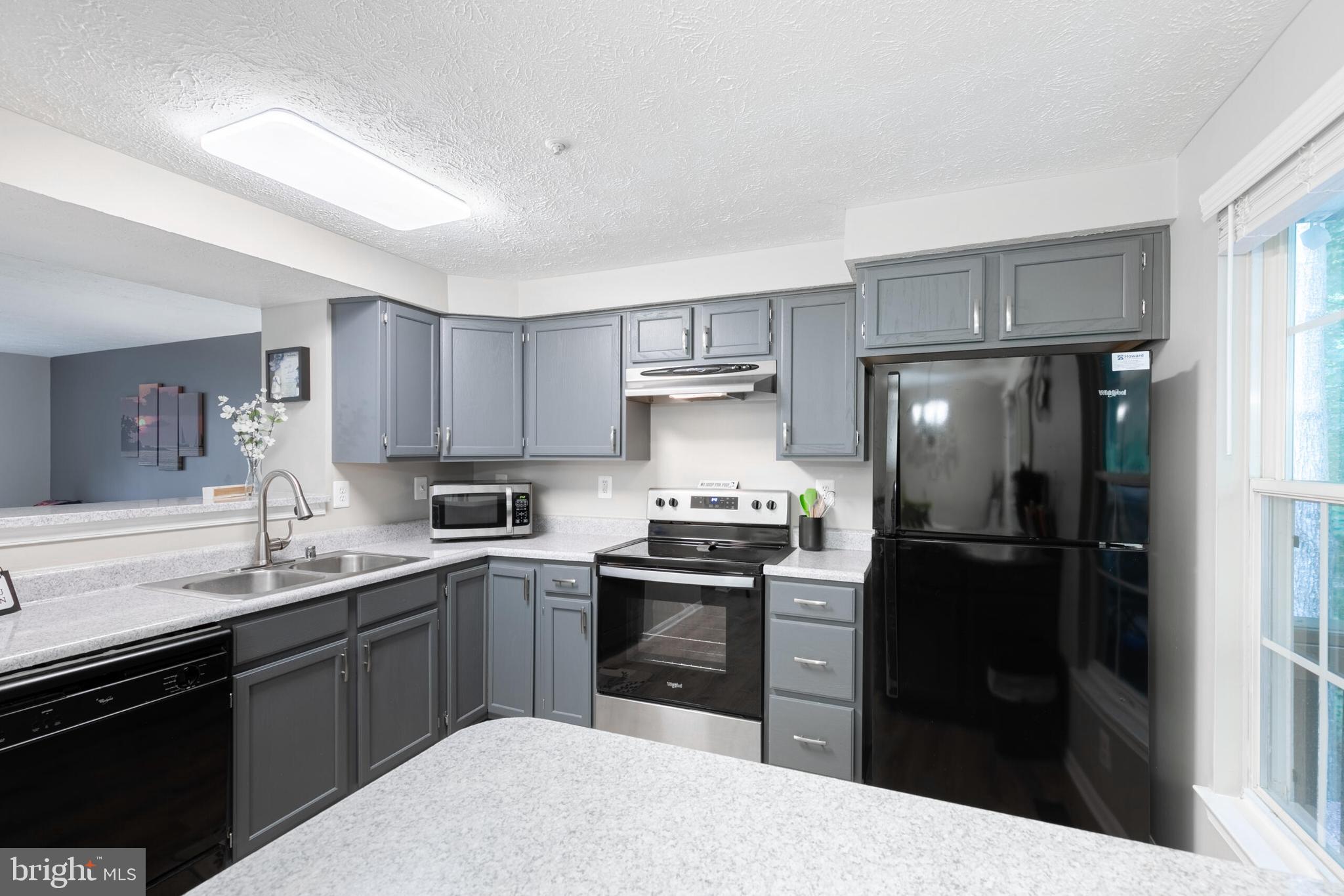 6058 Weekend Way, Unit G38 Columbia, MD 21044 - Photo 13 of 33 a kitchen with a sink a refrigerator a stove top oven and cabinets