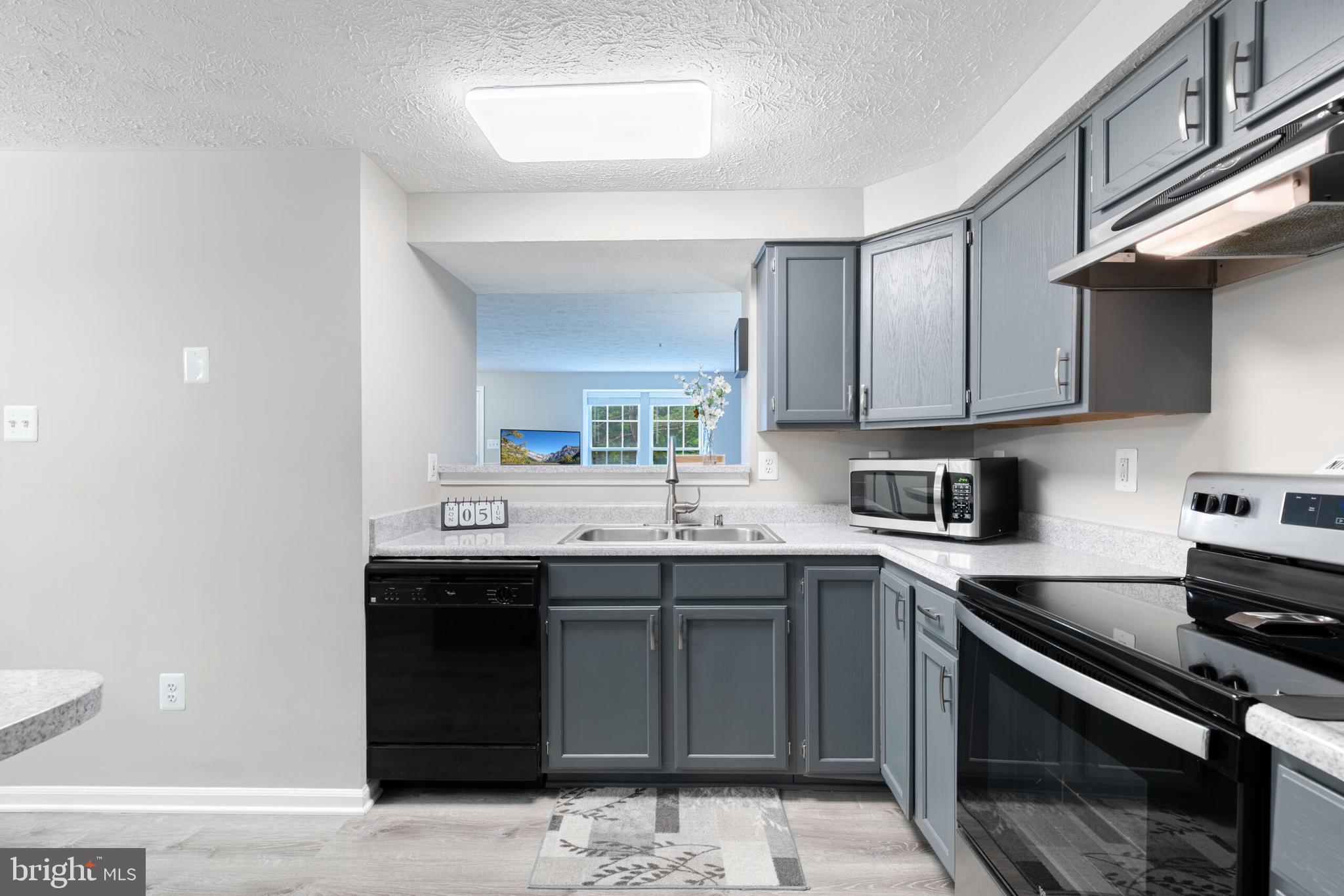 6058 Weekend Way, Unit G38 Columbia, MD 21044 - Photo 14 of 33 a kitchen with stainless steel appliances granite countertop a sink stove and cabinets