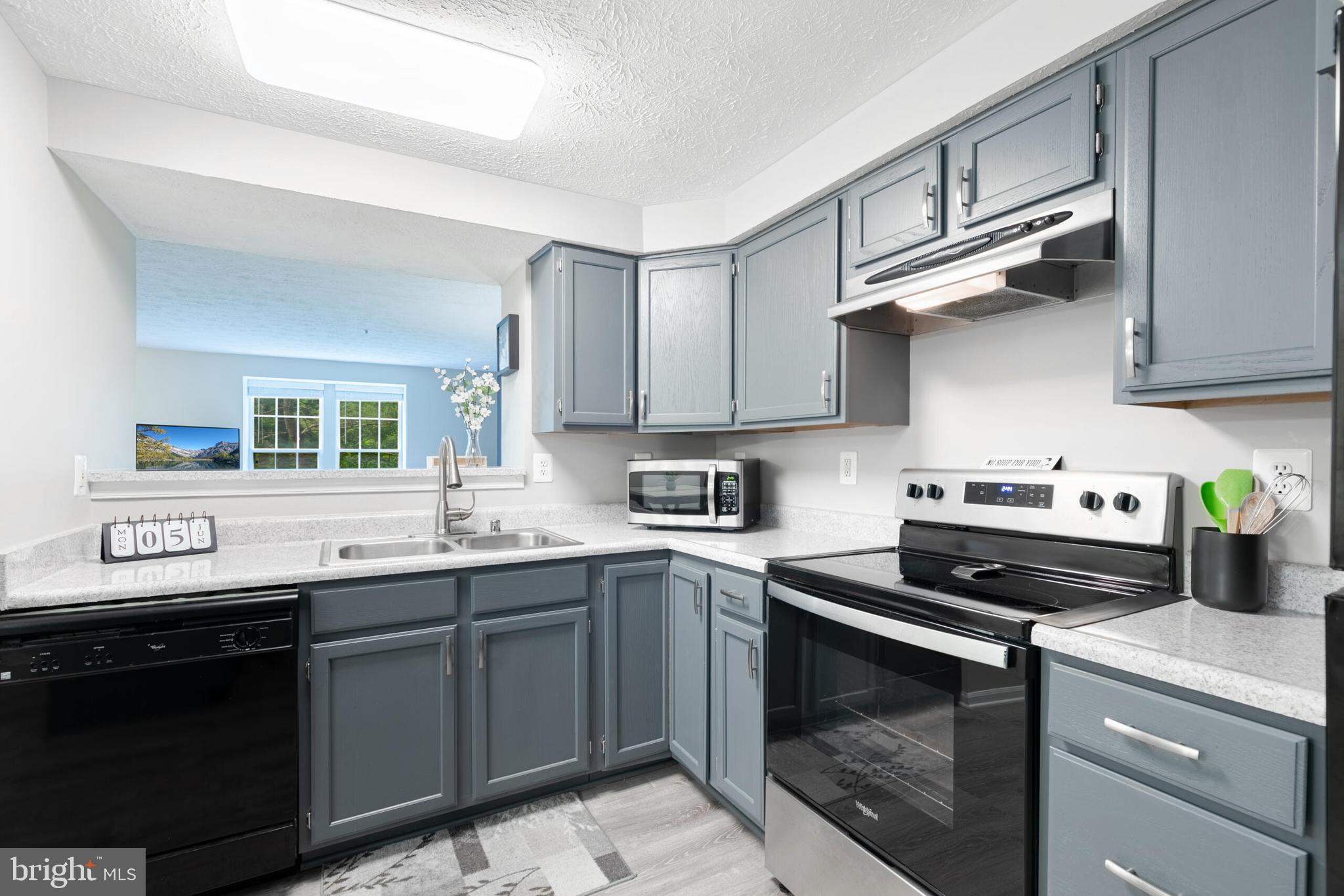 6058 Weekend Way, Unit G38 Columbia, MD 21044 - Photo 15 of 33 a kitchen with stainless steel appliances a sink stove and cabinets