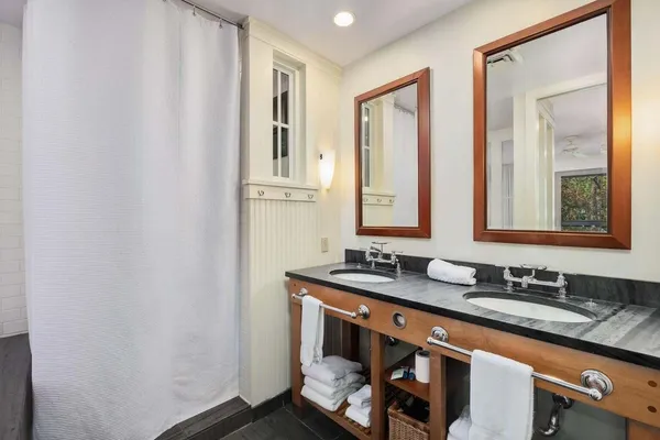 a bathroom with double sink and a mirror