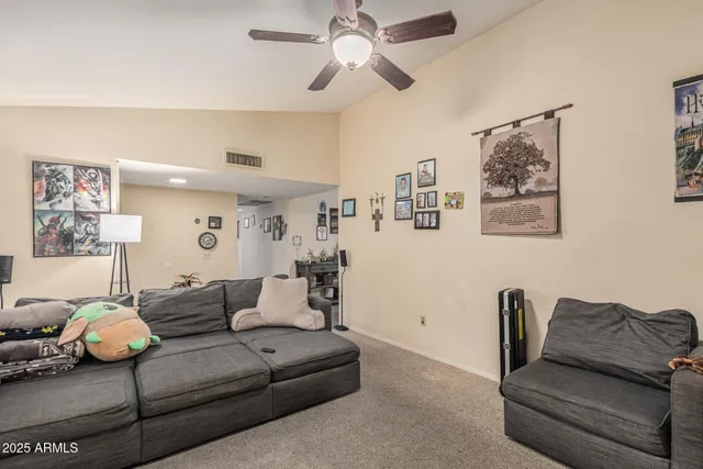 a living room with furniture and a ceiling fan