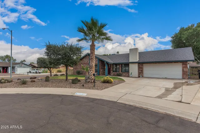 a view of a house with a patio and a yard