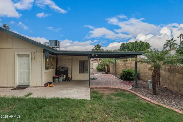 a view of a house with backyard and sitting area