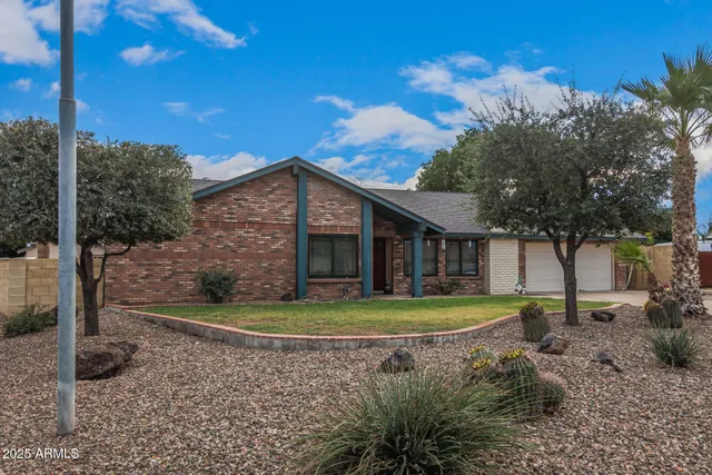 a view of a big house with a big yard and large trees