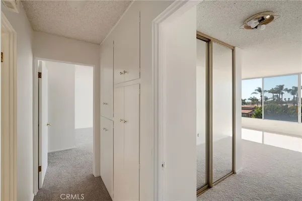 a view of a hallway with wooden floor and a bathroom