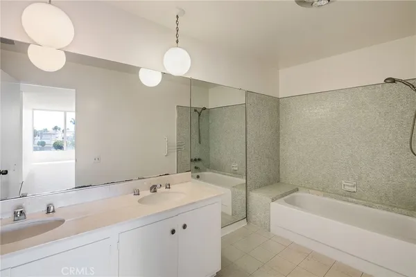 a bathroom with a tub sink and mirror