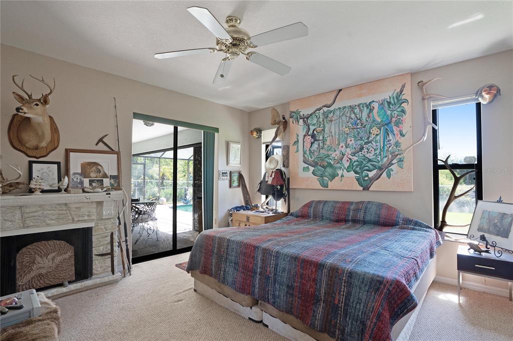 268 Cory Street Port Charlotte, FL 33953 - Photo 14 of 25 a bedroom with a large bed and a fireplace