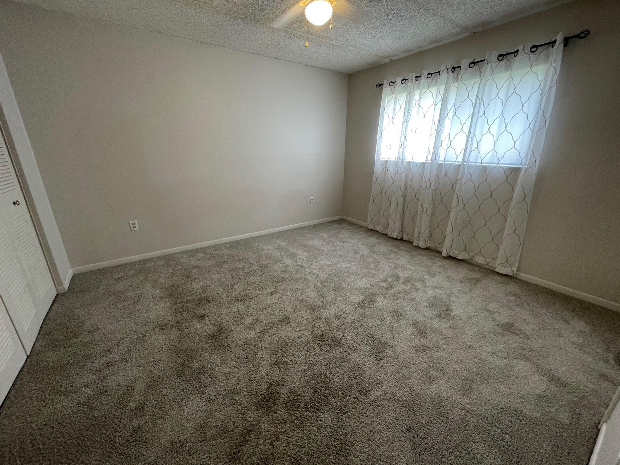601 Ridge Club Drive, Unit 1 Melbourne, FL 32934 - Photo 14 of 19 an empty room with stairs and windows