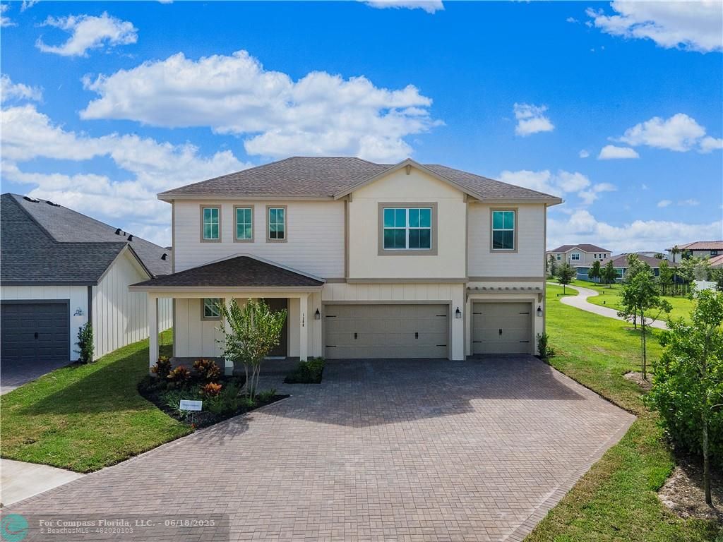 a front view of a house with a garden and yard