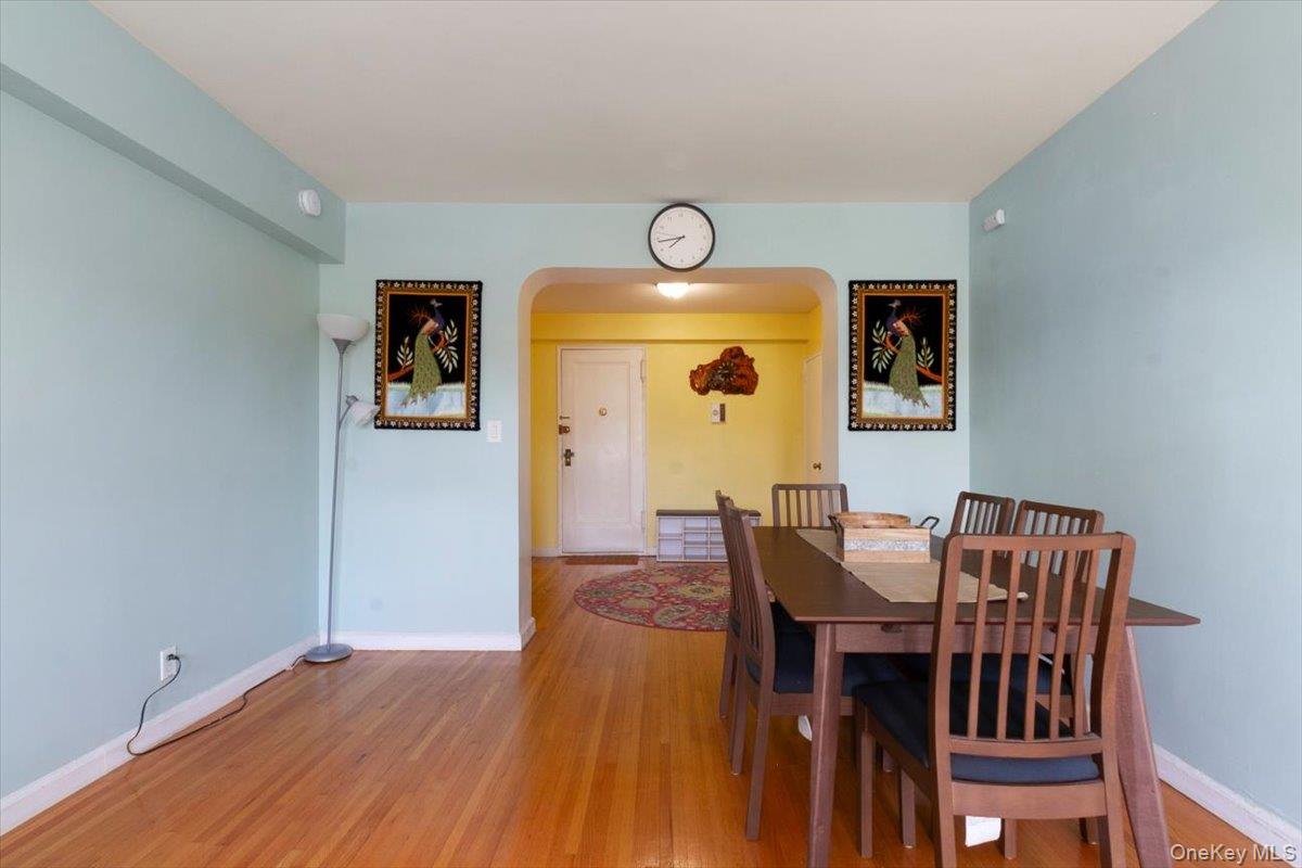 142 Garth Road, Unit 2H Scarsdale, NY 10583 - Photo 6 of 14 Dining space with light wood-style floors and arched walkways