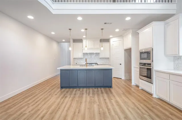 a large kitchen with kitchen island a sink stainless steel appliances and cabinets