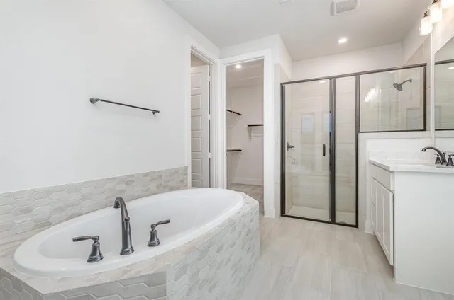 a bathroom with a tub a sink and mirror