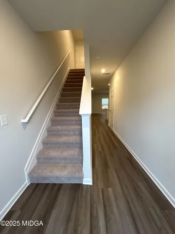 a view of entryway and hall with wooden floor