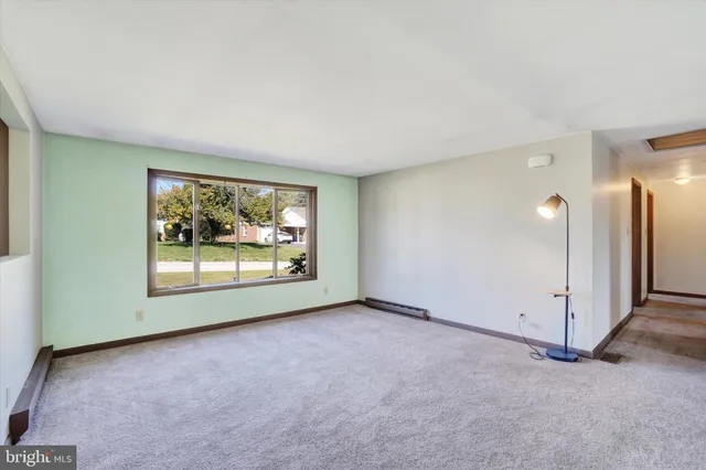 a view of an empty room with closet and a window