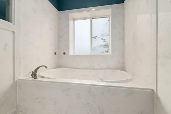 a white bath tub sitting next to a window